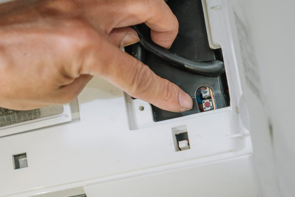 技師在清洗冷氣前確認並關閉總開關，確保電路安全，展現騰芸空調專業的施工流程與安全意識。