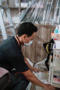 騰芸空調技師進行冷氣清洗前的環境防護作業，使用防水塑膠布覆蓋櫃體與牆面，確保施工過程乾淨無塵，展現專業與細節講究。