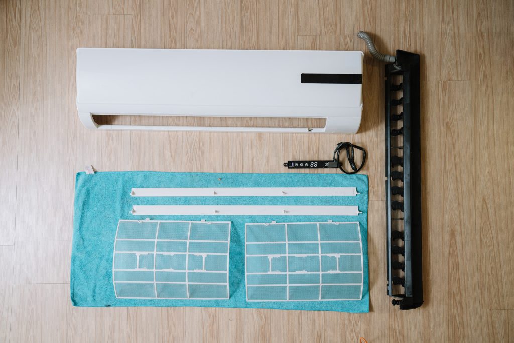 冷氣清洗後的零件整齊排列於毛巾上晾乾，包含面板、濾網、導風葉與控制面板，所有部件潔淨如新，展現騰芸空調細緻且標準化的清洗成果。