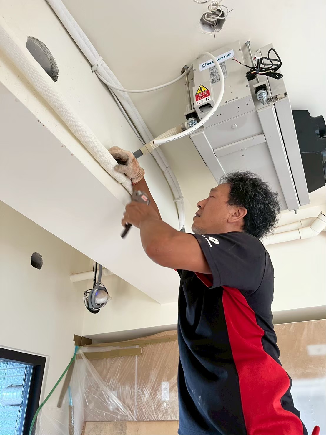 吊隱式除濕機排水管固定與管線包覆施工。